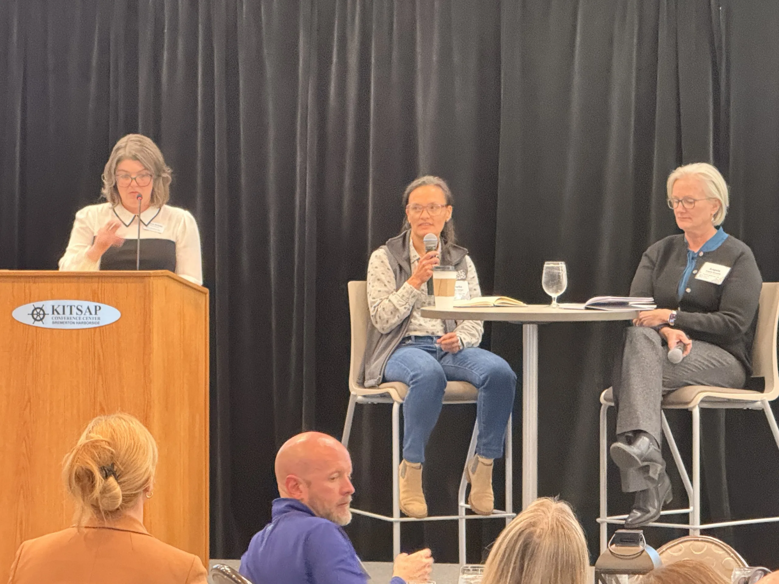 Moderator and two utility leaders on stage at the Greater Kitsap Chamber luncheon