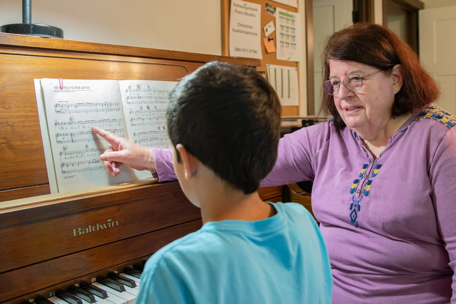 Kastanopolous guides a student through a piano lesson, drawing on decades of experience as a music teacher.